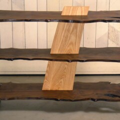 dark wood shelves joined by light wood vertical fin piece